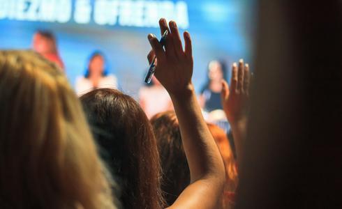 Woman raises hand at an event